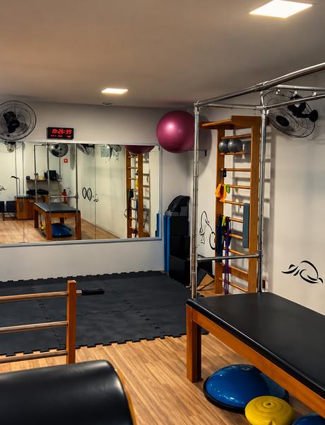 Sala de pilates com barra, bolas e aparelhos