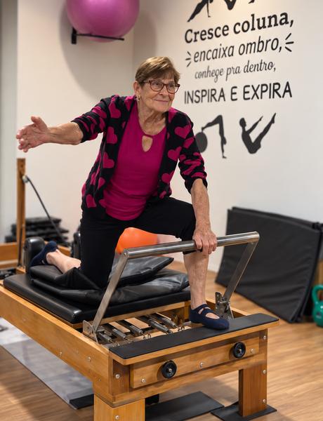 Aluna da terceira idade em exercício no reformer