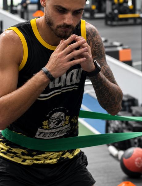 Aluno treinando força com elástico